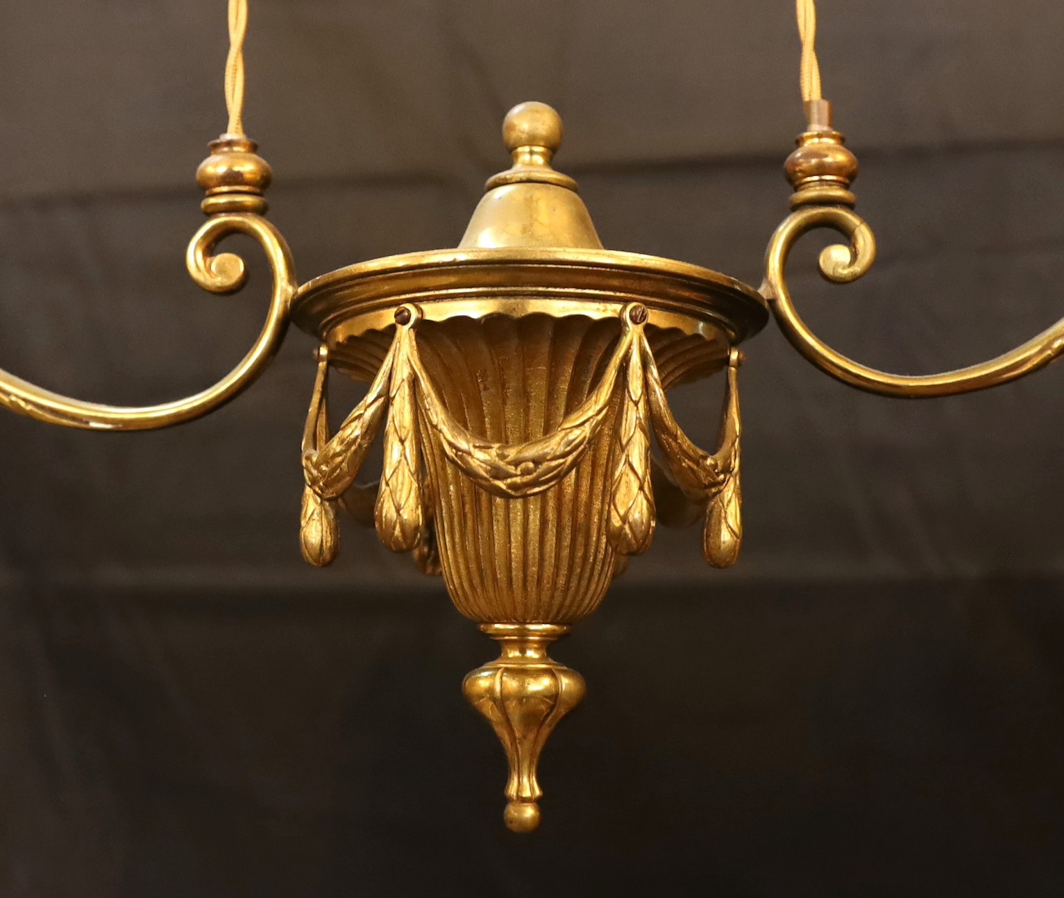 An early 20th century English ormolu counter balanced ceiling light with twin branches, swagged turn centre and yellow tinted frosted glass shades, height from 60 to 120cm